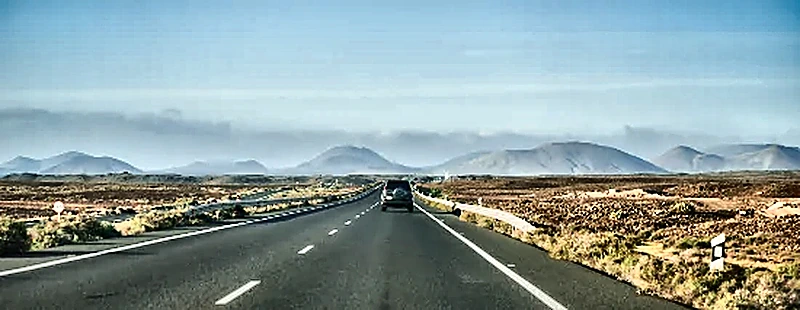 Strada asfaltata attraverso il paesaggio vulcanico di Lanzarote